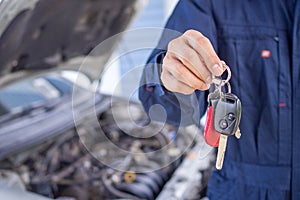 The engine engineer returned the car key to the owner after checking and fixing the car. Offsite service