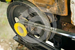 The engine of a garden walk-behind tractor close-up. Yellow Pulley Belt Driven Torque Transmission