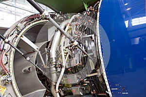 Engine of modern passenger jet plane close up. The bonnet is open. Engine maintenance.