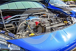 Engine under the hood of a modern blue car