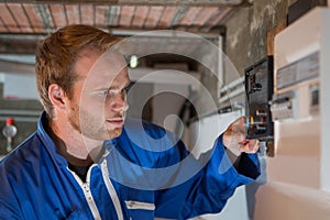 Engineer adjusting heating system thermostat