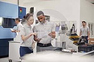 Engineer And Apprentice Meet On Floor Of Engineering Workshop