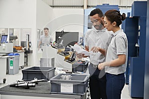 Engineer And Apprentice Meet On Floor Of Engineering Workshop