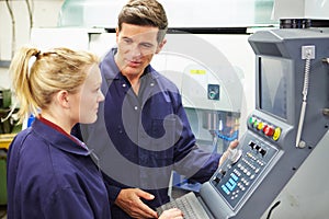 Engineer And Apprentice Using Automated Milling Machine photo