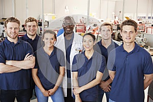 Engineer with apprentices in factory, group portrait