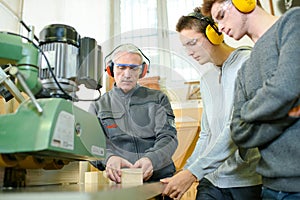 engineer and apprentices using automated milling machine