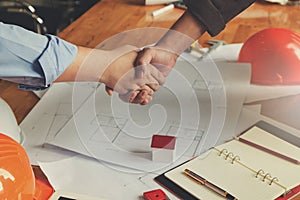Engineer and Architect concept, Engineer Architects shaking hand with blueprints background