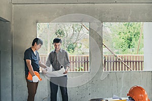 Engineer and architect discussing with foreman about project in building construction site