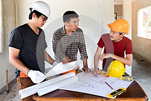 Engineer and architect discussing with foreman about project in building construction site