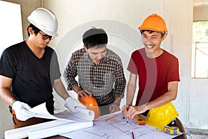 Engineer and architect discussing with foreman about project in building construction site