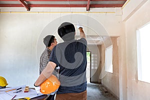 Engineer or architect discussing with foreman about project in building construction site