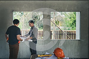 Engineer and architect discussing with foreman about project in building construction site