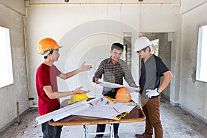 Engineer and architect discussing with foreman about project in building construction site