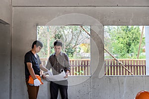 Engineer and architect discussing with foreman about project in building construction site