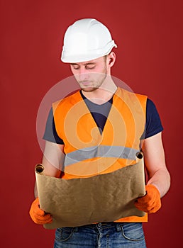 Engineer, architect, labourer, builder on strict face holds old blueprint in hands. Engineering concept. Man, handyman