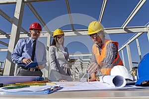 Engineer, Architect and Smiling Businessman Checking the Construction Blueprint on Construction Site