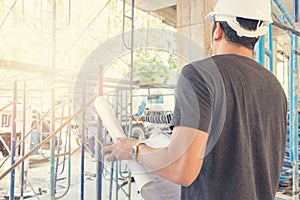 Engineer and Architect working at Construction Site with blueprint