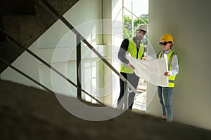 Engineer and architect working on the construction site, double-checking plans