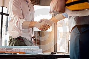 Engineer and architecture shaking hand after finish an agreement in the office. Civil engineering, Architect concept