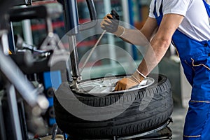 Engineer balancing car wheel on balancer