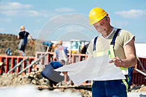 Engineer builders at construction site with draft