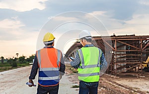 Engineer and builders in hardhats discussing on construction site, Engineer and foreman worker checking project at building site,