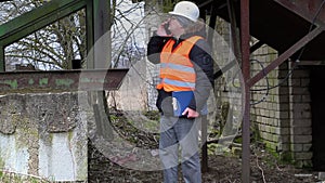 Engineer with cell phone at old factory