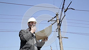 Engineer check electrical systems talk walkie-talkie, Inspector holding blueprints plan