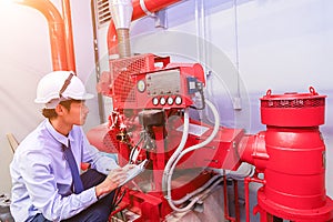 Engineer check red generator pump for water sprinkler piping and fire alarm control.