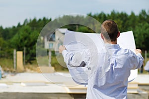 Engineer checking a building plan on site