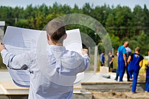 Engineer checking a building plan on site