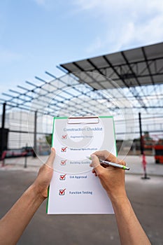 An engineer is checking construction quality on the paperwork.