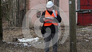 Engineer checking documentation near powerline