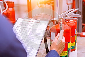 Engineer checking fire extinguisher.