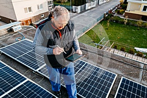 Engineer checking solar panel setup. Using smart app in tablet
