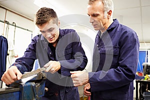 Engineer Checking Trainee's Work On Factory Floor