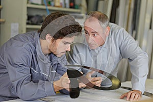Engineer checking trainees work on factory floor