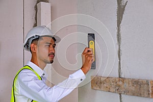 Engineer is checking wall level in building site