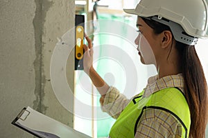 Engineer is checking wall level in building site