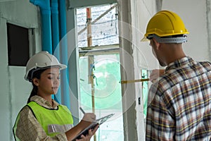 Engineer is checking wall level in building site