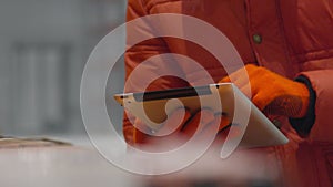 Engineer checks the documents on tablet inside new modern industry warehouse