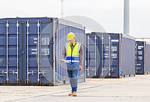 Engineer with clipboard checklist in industry containers cargo, Foreman dock worker in hardhat and safety vest control loading