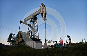 Engineer with clipboard fixing performance of operation oil rig.