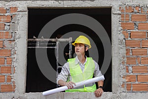 Engineer concept The building schemer standing inside the building with stern face while viewing some details of the construction