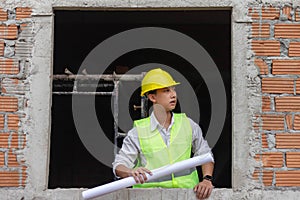 Engineer concept The building schemer standing inside the building with stern face while viewing some details of the construction