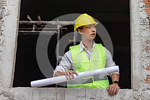 Engineer concept The building schemer standing inside the building with stern face while viewing some details of the construction