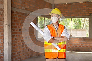 Engineer concept The male engineer standing in the building and looking at many workers doing their job photo