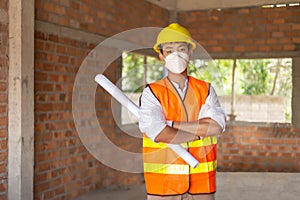 Engineer concept The male engineer standing in the building and looking at many workers doing their job photo