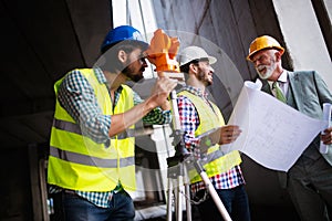 Engineer and construction site manager dealing with blueprints and plans