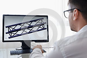 Engineer, Constructor, Designer, Architect in Glasses Working on a Personal Computer. He Creating New Component of beam